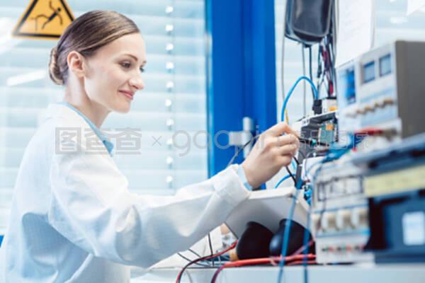 在試驗臺上測量電子產(chǎn)品的工程師